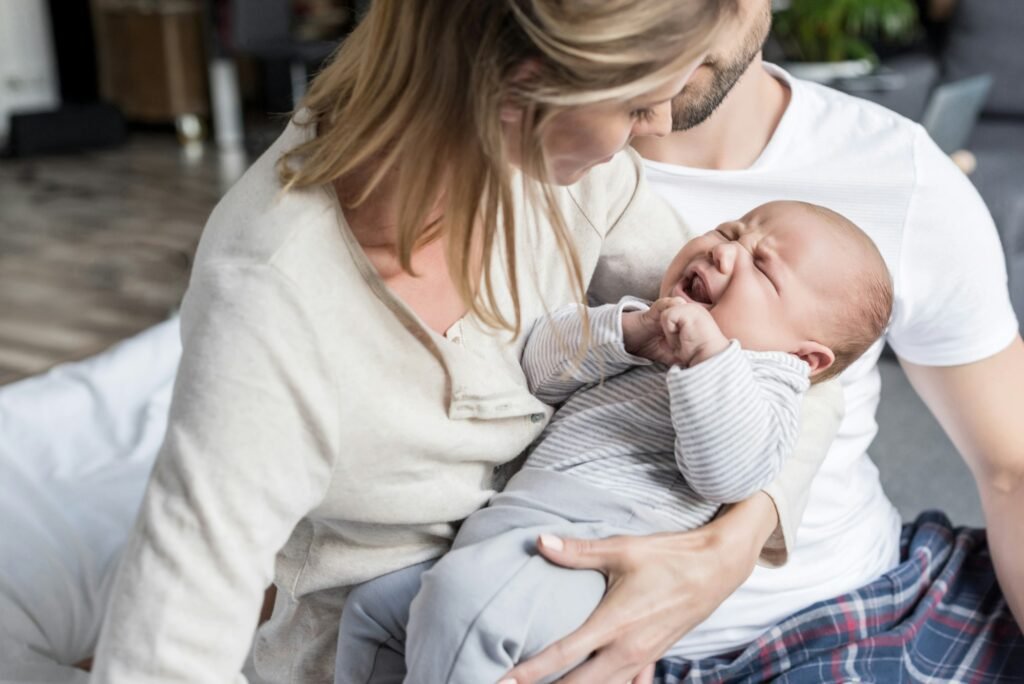 young parents holding ther little crying baby