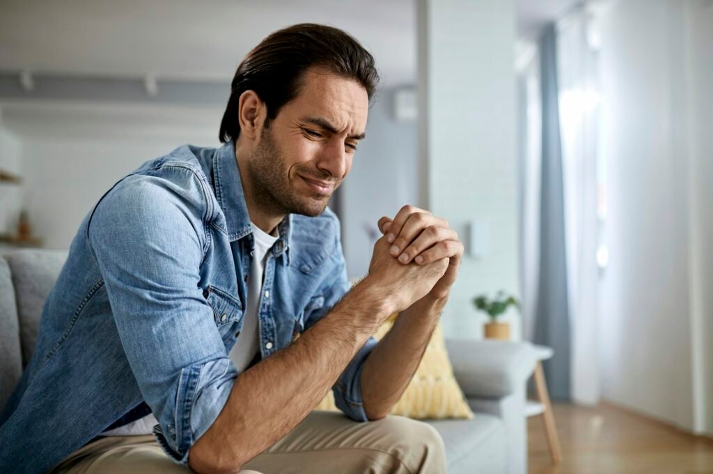 Young sad man crying at home.